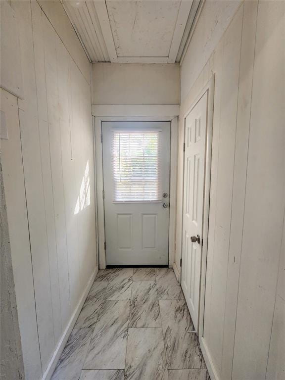 entryway with wood walls