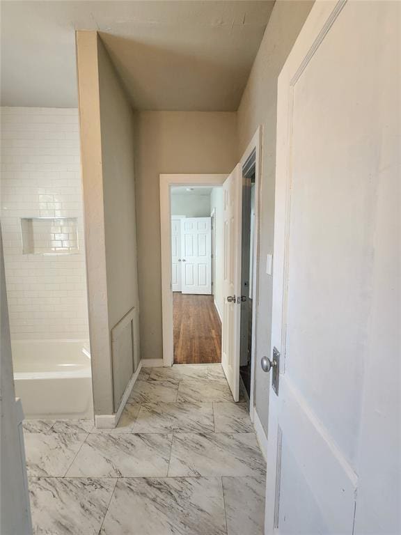 bathroom featuring hardwood / wood-style flooring and a tub to relax in