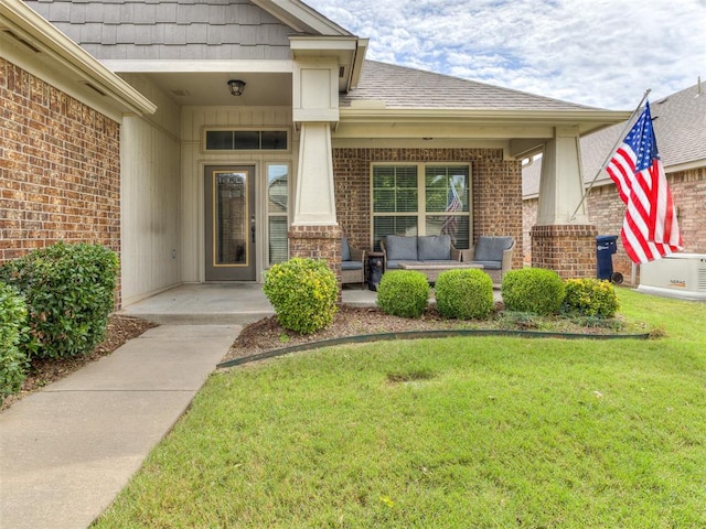 entrance to property featuring outdoor lounge area and a yard