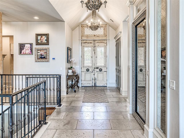 foyer entrance featuring an inviting chandelier and lofted ceiling