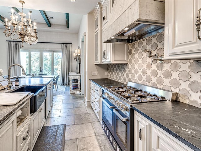 kitchen with an inviting chandelier, range with two ovens, tasteful backsplash, beam ceiling, and custom range hood