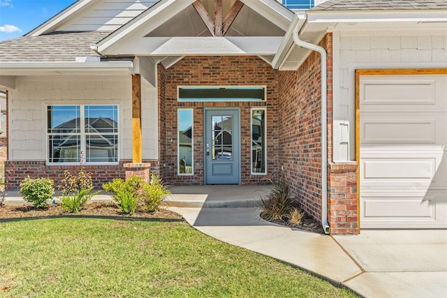 entrance to property featuring a garage and a yard