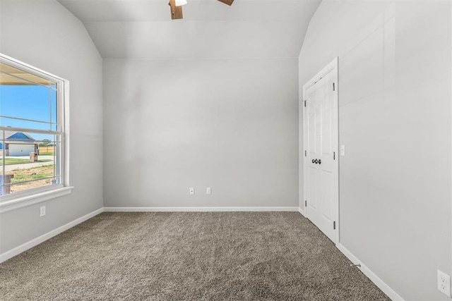 empty room featuring ceiling fan, carpet, and vaulted ceiling