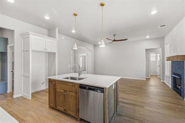 kitchen featuring sink, stainless steel dishwasher, light hardwood / wood-style floors, a center island with sink, and white cabinets