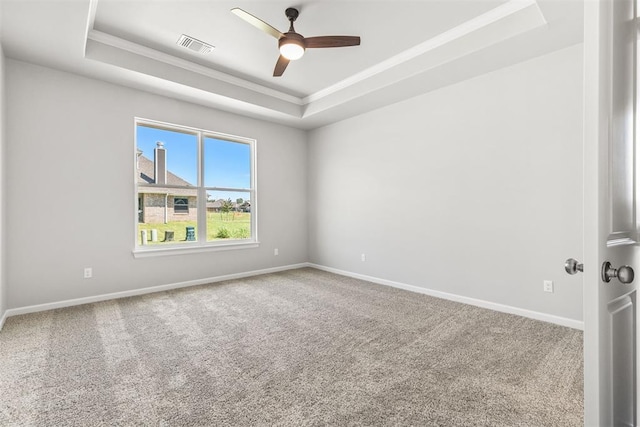empty room featuring carpet floors, a raised ceiling, and ceiling fan