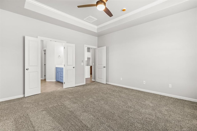 unfurnished bedroom with light colored carpet, a raised ceiling, and ceiling fan