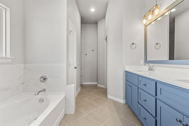 bathroom with tile patterned flooring, vanity, and a bath