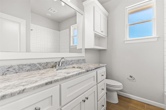 full bathroom featuring hardwood / wood-style floors, vanity, tub / shower combination, and toilet