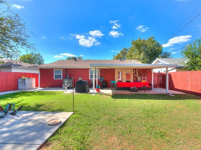 rear view of property featuring a yard, a patio area, and outdoor lounge area