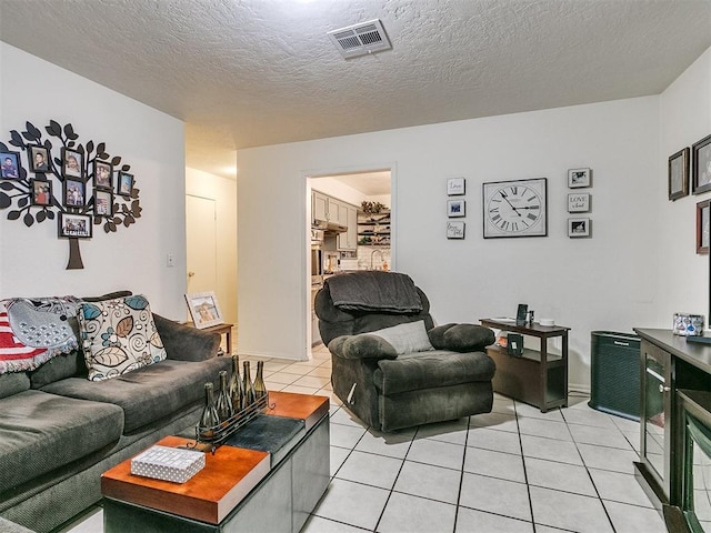 tiled living room featuring a textured ceiling