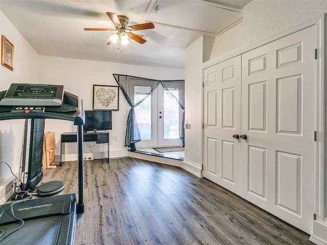 exercise room featuring ceiling fan, dark hardwood / wood-style flooring, and french doors