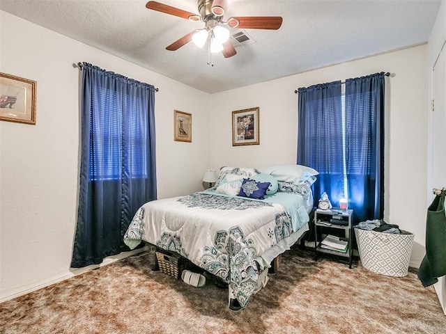 bedroom featuring carpet flooring, ceiling fan, and a textured ceiling