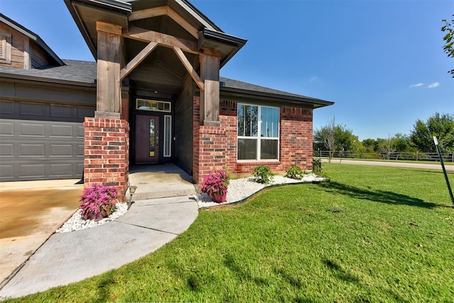 view of exterior entry with a lawn and a garage