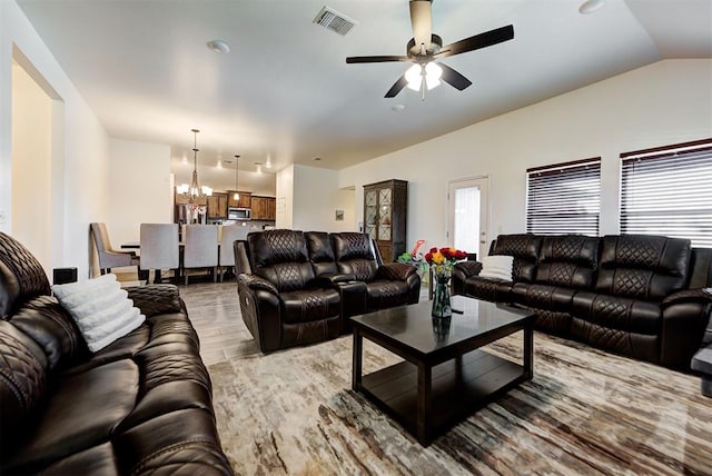 living room with light hardwood / wood-style flooring, ceiling fan with notable chandelier, and lofted ceiling