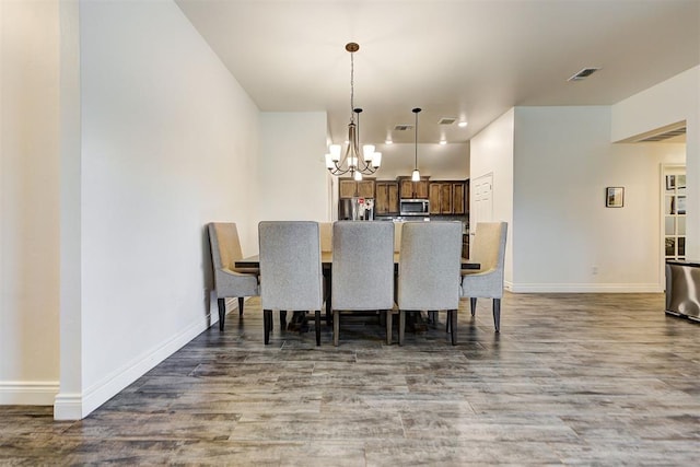 dining room featuring a notable chandelier and dark wood-type flooring