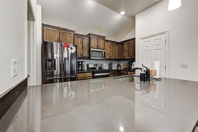 kitchen featuring decorative backsplash, sink, stainless steel appliances, and lofted ceiling