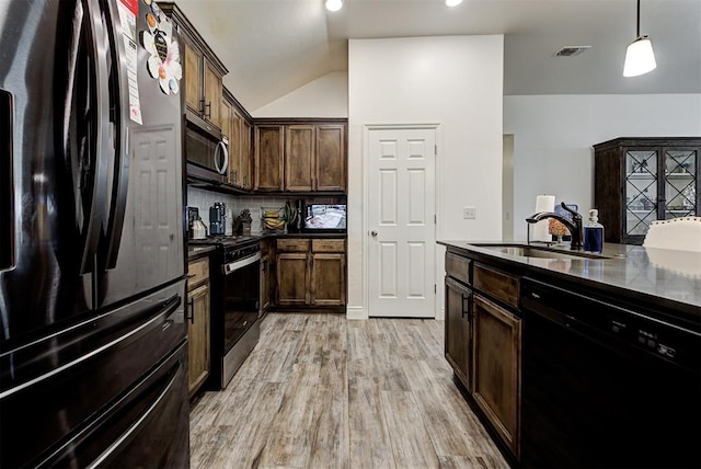 kitchen featuring sink, hanging light fixtures, light hardwood / wood-style floors, vaulted ceiling, and appliances with stainless steel finishes