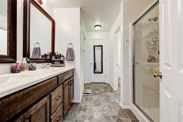 bathroom featuring toilet, an enclosed shower, and vanity