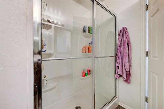 bathroom featuring a shower with door