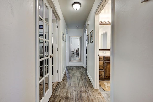 corridor with light wood-type flooring and french doors