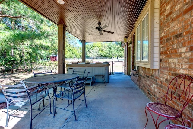 view of patio with ceiling fan and a hot tub