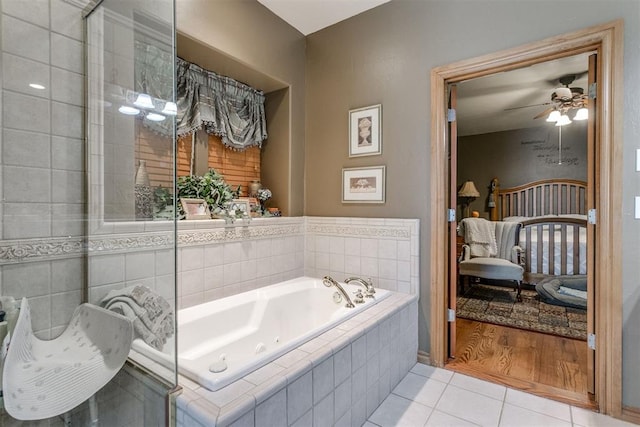 bathroom featuring tiled tub, ceiling fan, and wood-type flooring