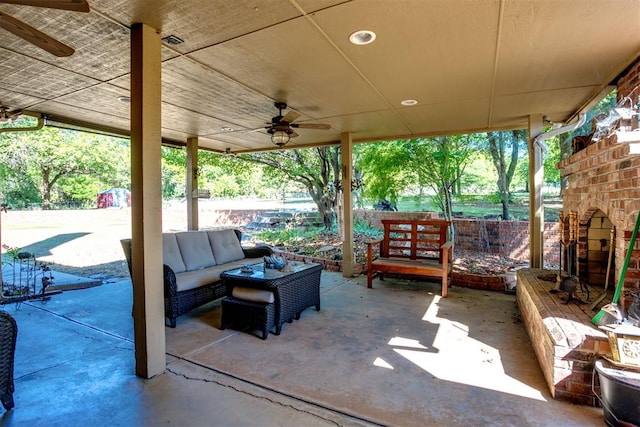 view of patio / terrace featuring an outdoor living space with a fireplace and ceiling fan