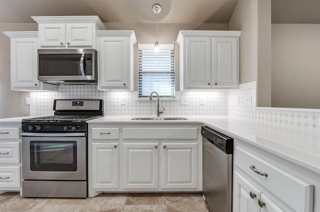 kitchen featuring decorative backsplash, stainless steel appliances, white cabinetry, and sink