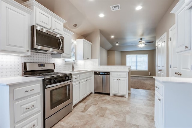 kitchen with white cabinetry, kitchen peninsula, sink, and appliances with stainless steel finishes