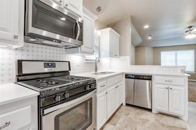 kitchen with backsplash, sink, kitchen peninsula, white cabinetry, and stainless steel appliances