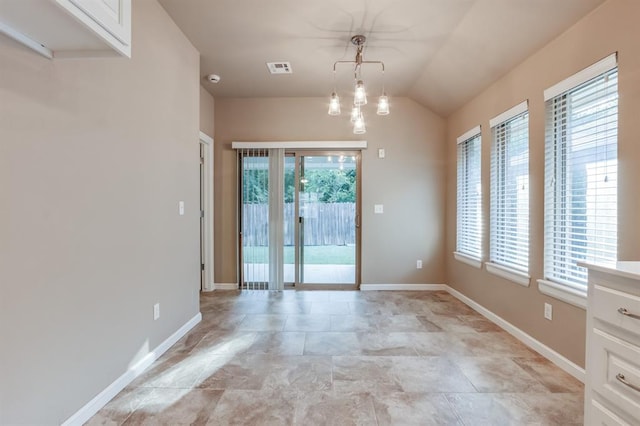 spare room with a chandelier, lofted ceiling, and a healthy amount of sunlight