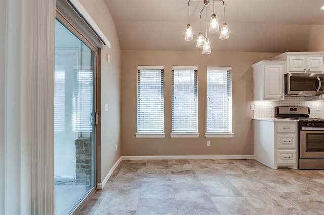 kitchen with a notable chandelier, backsplash, decorative light fixtures, white cabinets, and appliances with stainless steel finishes