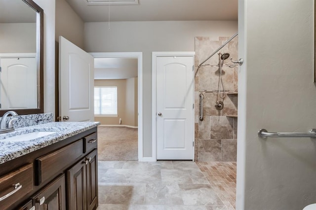 bathroom featuring a tile shower and vanity