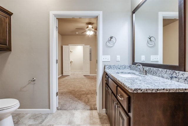 bathroom with tile patterned flooring, vanity, ceiling fan, and toilet