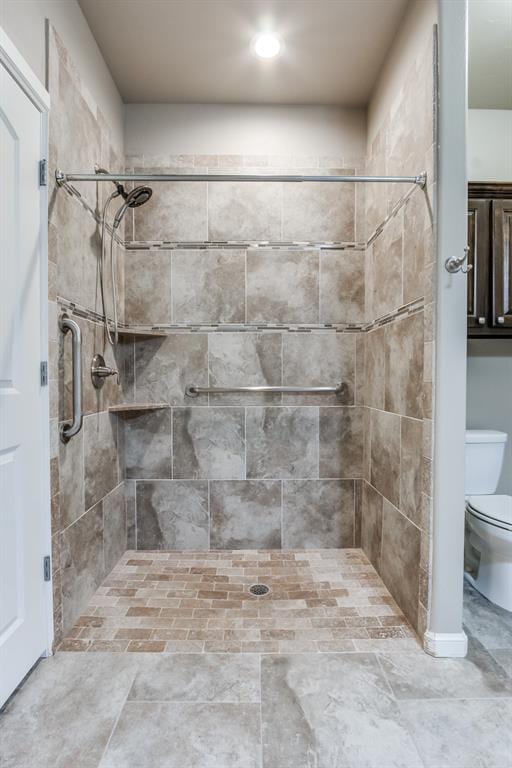 bathroom with tiled shower and toilet