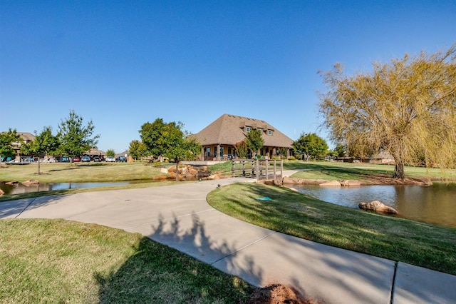 view of community with a water view and a yard