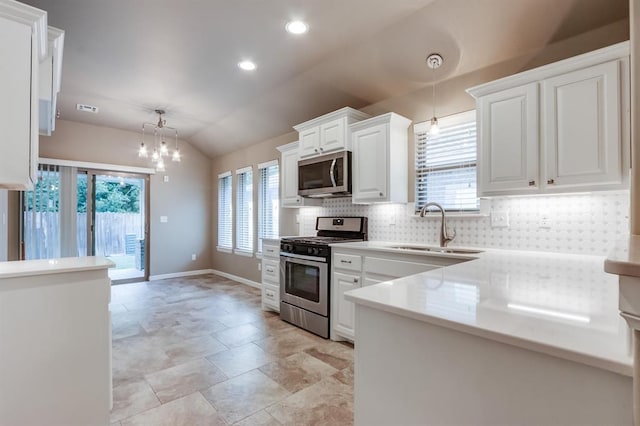 kitchen with white cabinets, appliances with stainless steel finishes, vaulted ceiling, and plenty of natural light