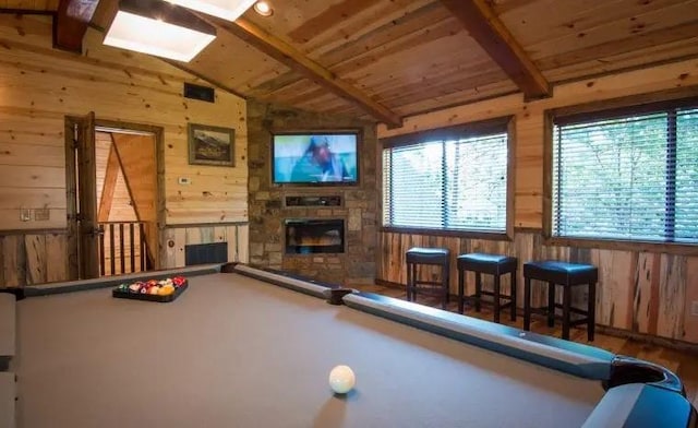 playroom with wooden ceiling, lofted ceiling with beams, billiards, wooden walls, and a fireplace