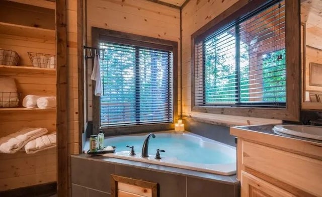 bathroom with vanity and tiled tub