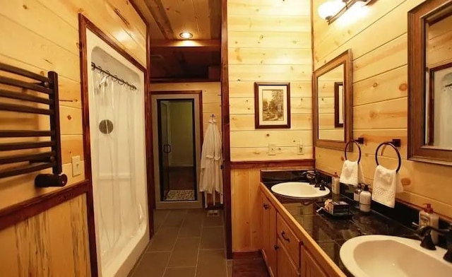 bathroom featuring tile patterned floors, wooden walls, and vanity