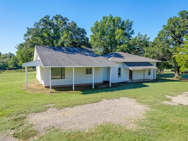 rear view of property featuring a porch and a yard