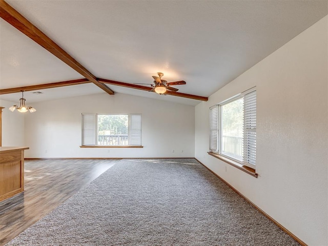 unfurnished room with ceiling fan with notable chandelier, wood-type flooring, and lofted ceiling with beams