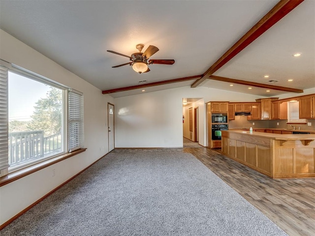 kitchen featuring lofted ceiling with beams, light hardwood / wood-style floors, ceiling fan, and black appliances