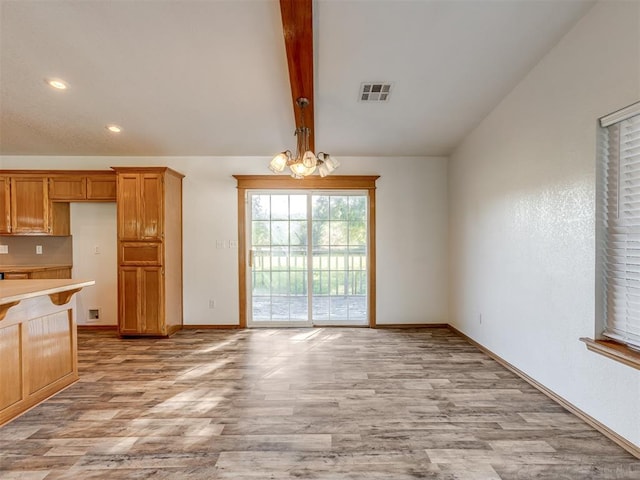 kitchen featuring vaulted ceiling with beams, a notable chandelier, and light hardwood / wood-style floors