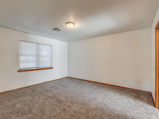 carpeted spare room with a textured ceiling