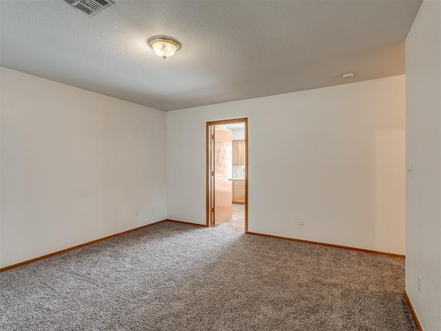 empty room featuring carpet flooring and a textured ceiling