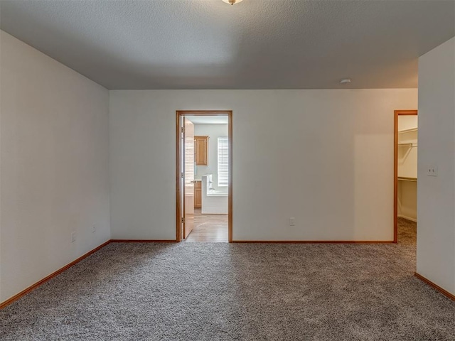 carpeted empty room with a textured ceiling