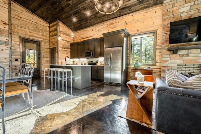 180 Alumacraft Trl, Broken Bow, OK 74728 - kitchen with stainless steel appliances, healthy amount of natural light, open floor plan, wood walls, and wood ceiling