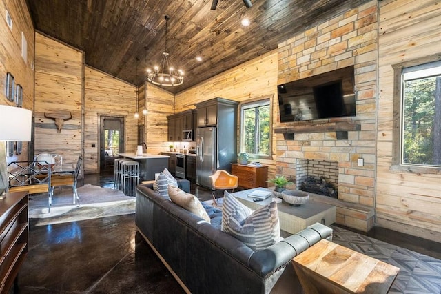 180 Alumacraft Trl, Broken Bow, OK 74728 - living area with wood walls, wood ceiling, a stone fireplace, lofted ceiling, and a chandelier