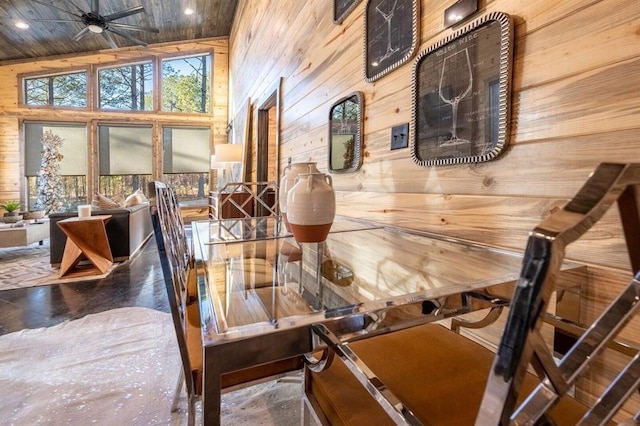 interior space featuring wood walls, concrete flooring, and high vaulted ceiling